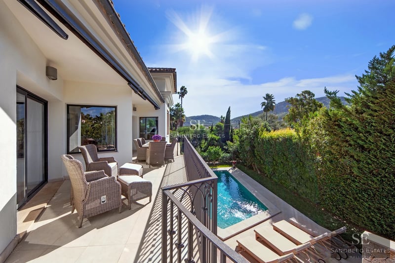 Spacious terrace with pool, sun loungers, lush greenery and unobstructed views. Modern and elegant design.