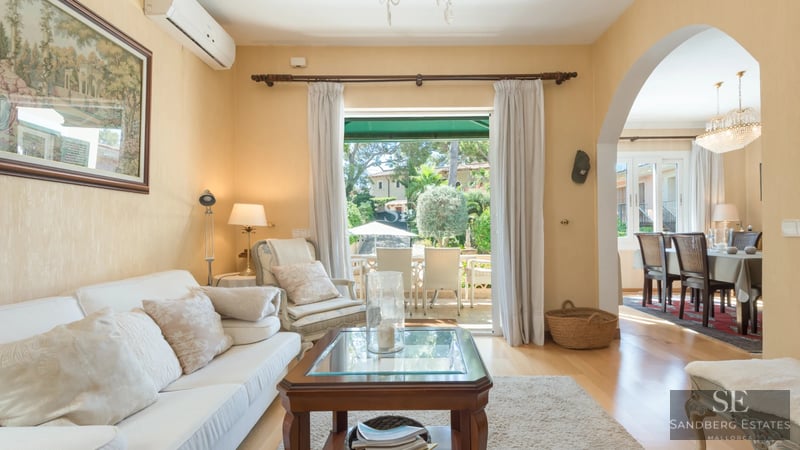 Exterior view of a modern villa featuring an infinity pool, expansive terraces, and lush gardens. Minimalist architecture with large windows.