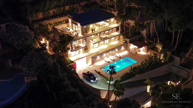 View of luxurious villa with infinity pool, sun loungers, modern architecture, and lush greenery. Minimalist and elegant design.