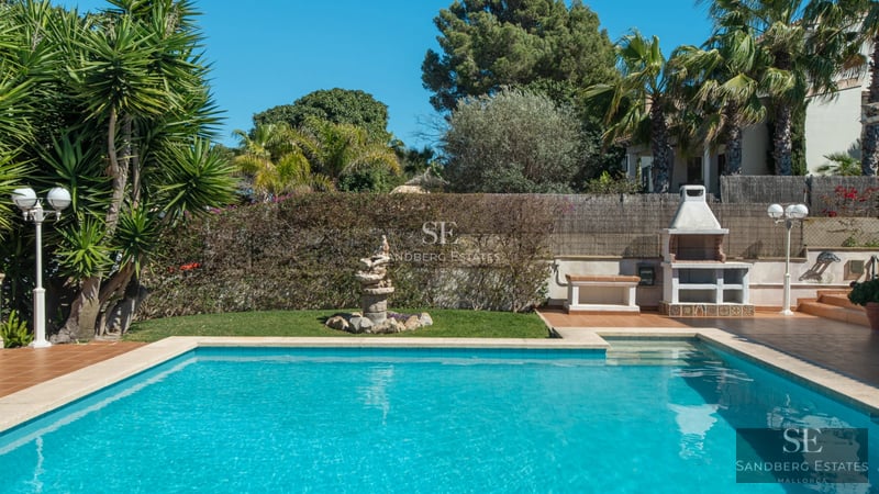 Large balcony with sea view. Modern design, glass railing, wooden floor. Soft lighting and elegant furniture.