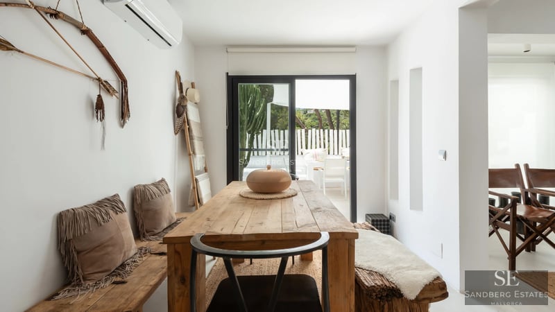 Vista exterior de una lujosa villa con piscina, arquitectura moderna, amplios ventanales y exuberante vegetación. Diseño minimalista.