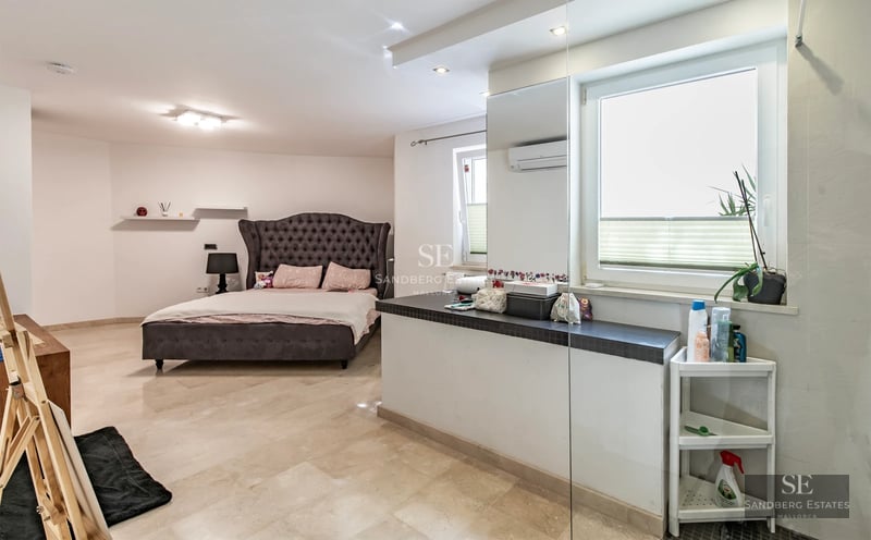 View of reflecting pool, modern facade, lush vegetation. Minimalist design with ambient lighting.