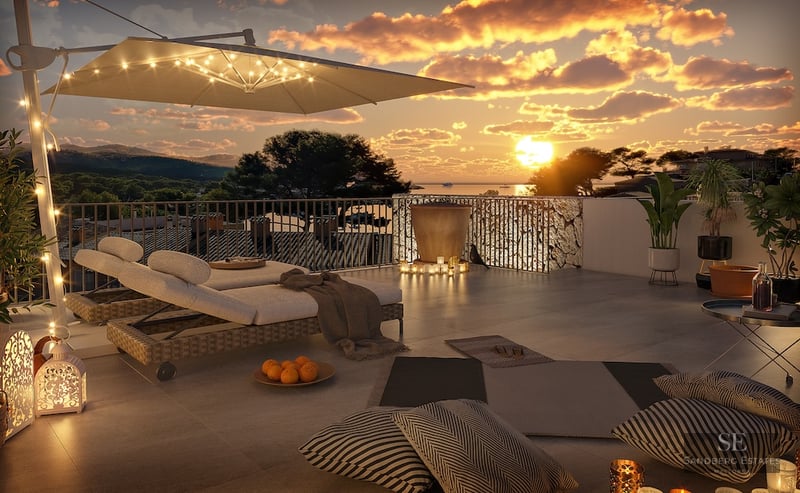 A luxury rooftop terrace at sunset featuring designer loungers, warm ambient lighting, and panoramic sea views.