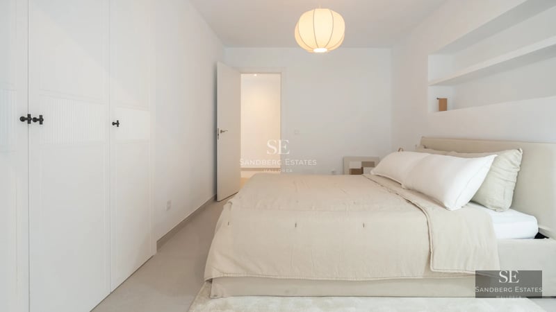 Spacious balcony with sea view. Modern design with glass railing, outdoor furniture, and wooden flooring.