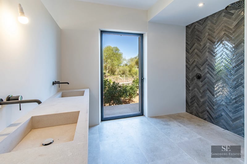 Exterior view of a modern villa with infinity pool, lush garden, and minimalist architectural design. Abundant natural light.