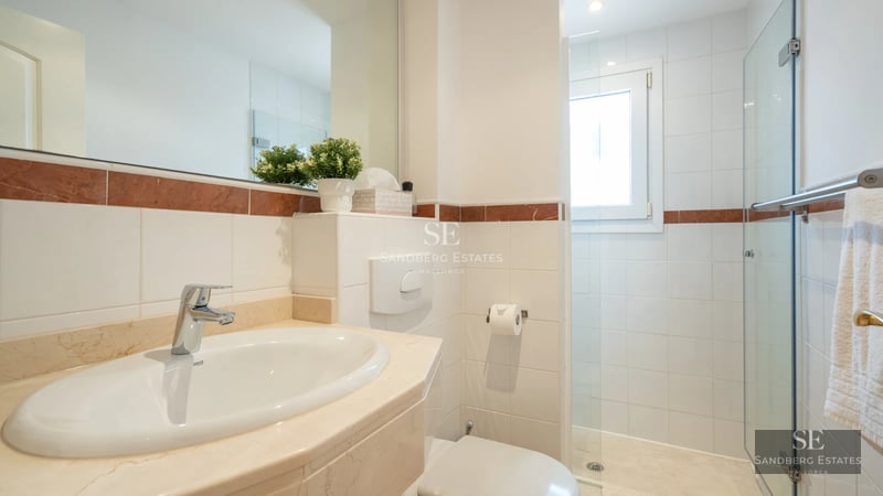 View of a luxurious villa with infinity pool, large windows, and modern design. Landscaped exteriors.