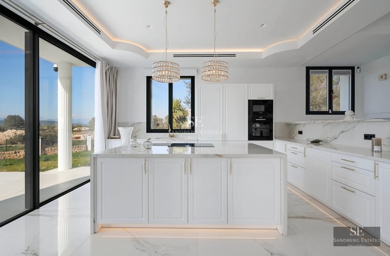 Spacious living room with pool access. Large windows, light wood floors, modern sofas, and unobstructed views. Abundant natural light.