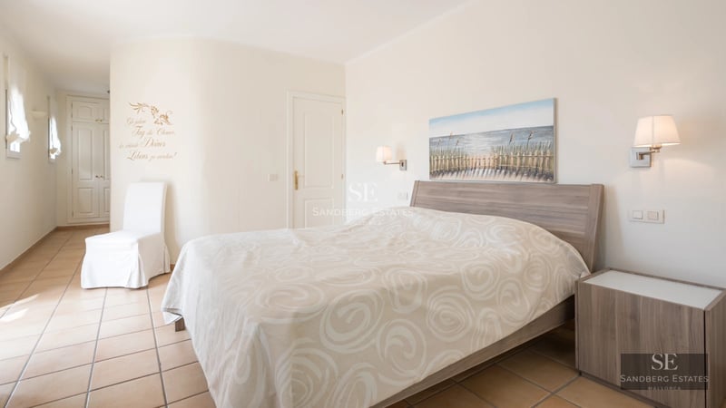 Spacious living room with large windows, modern furniture, and access to balcony with sea view. Natural lighting.