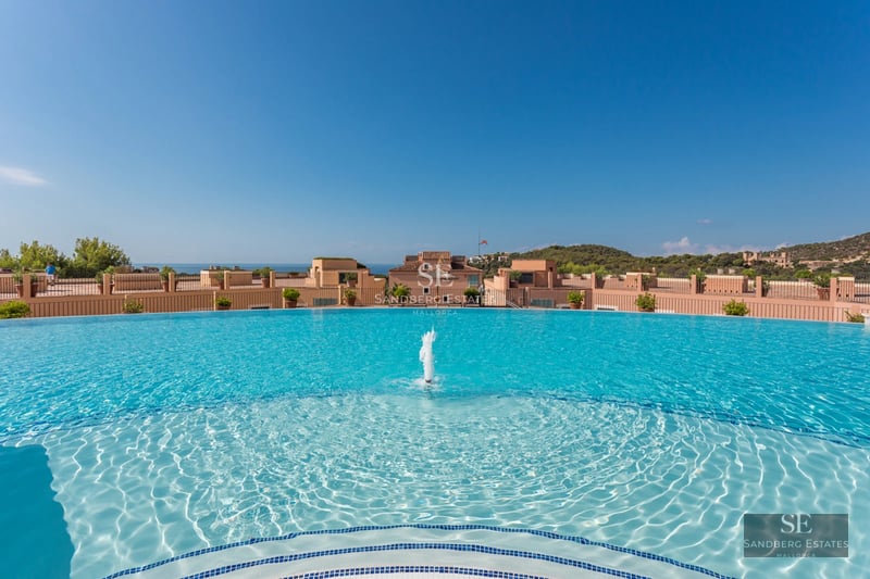 Modern penthouse with a large terrace, glass railings and spectacular views. Minimalist design, high-end outdoor furniture.