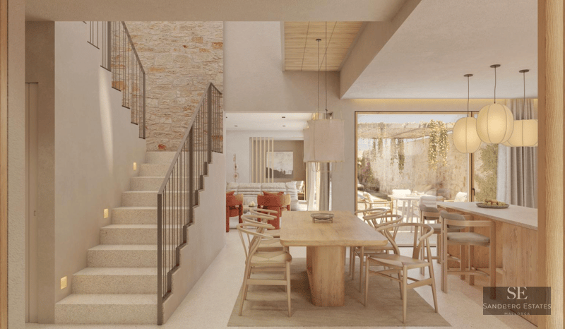 Bright modern interior featuring a large wooden dining table, stone feature wall, and an elegant stone staircase.