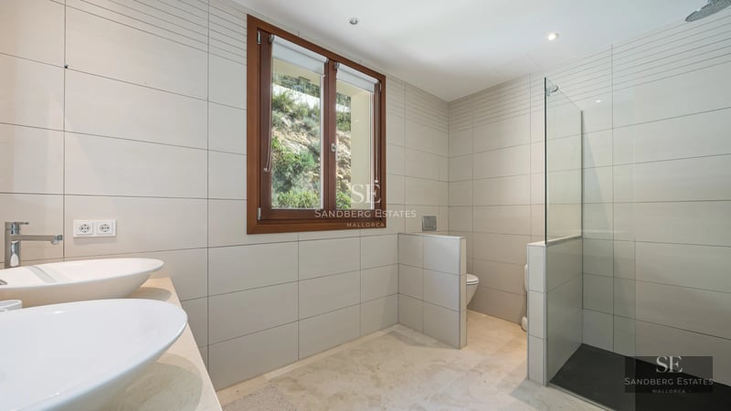 Exterior view of a luxurious house featuring a pool, manicured garden, and modern architecture with large windows.