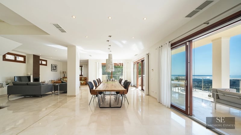 Expansive terrace featuring an infinity pool and ocean views. Modern architecture, stylish outdoor furniture, and lush greenery.
