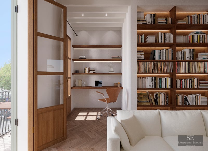 Modern home office nook featuring a wooden desk, floating shelves, and a large built-in bookshelf next to a white sofa.