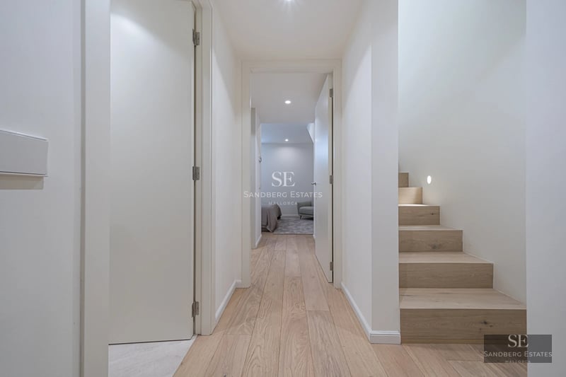 Pool view with sun loungers and umbrellas, bordered by garden and lush vegetation. Modern architecture with large windows.