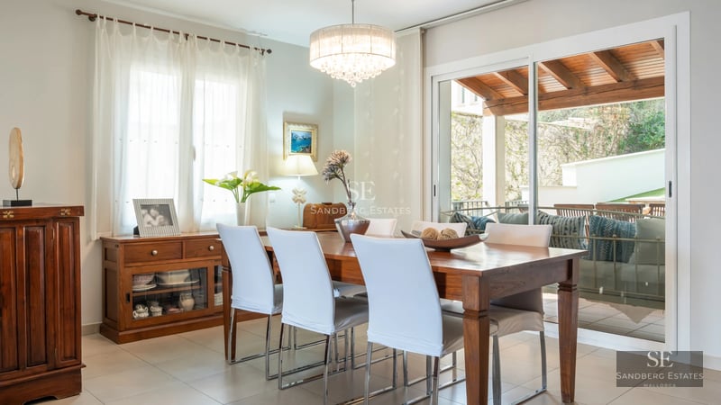 Spacious living room with large windows, panoramic views, light wood flooring, and modern furniture. Abundant natural light.