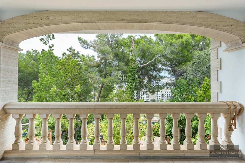 Spacious living room with panoramic windows, modern fireplace, light wood floors, and contemporary designer furniture. Sea view.