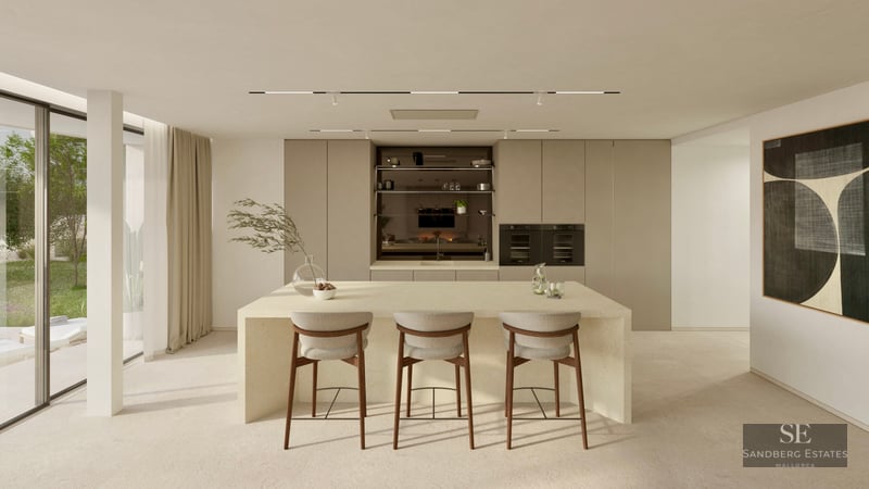 Bright minimalist kitchen featuring a large stone island with three bar stools and garden views through glass doors.