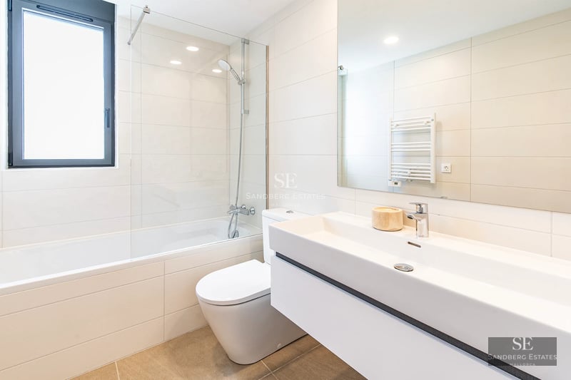 Exterior view of a modern villa featuring an infinity pool, lush garden, and minimalist architectural design.