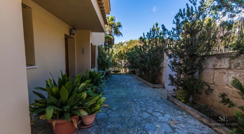 Spacious balcony with sea view from a modern apartment. Glass railing, elegant furniture, and natural light.