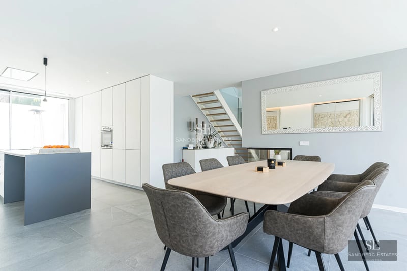 Panoramic view of a modern villa with an infinity pool and expansive terraces. Minimalist architecture and luxurious finishes.