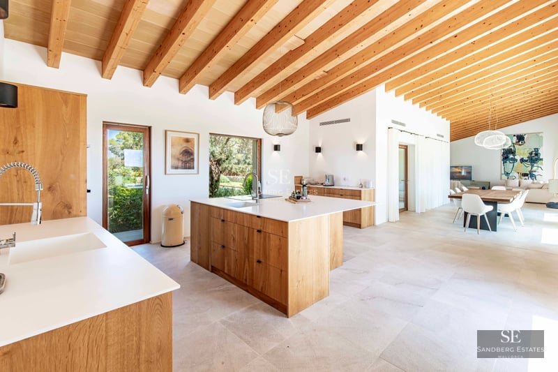 Exterior view of a modern villa featuring a pool, lush garden, and spacious terraces. Minimalist architecture with clean lines and large windows.