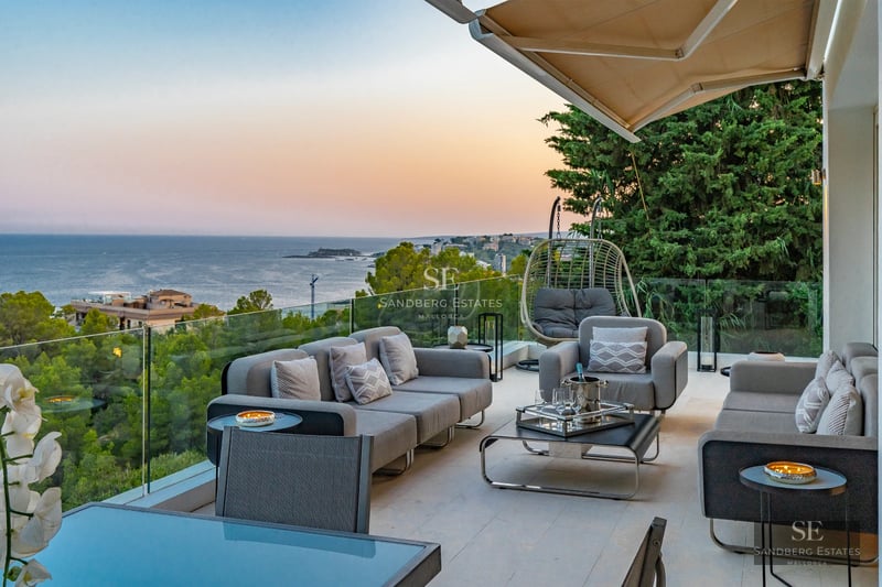 Expansive terrace featuring infinity pool, panoramic sea views, and modern furnishings. Minimalist design with soft ambient lighting.