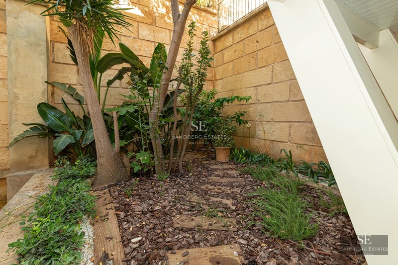 Spacious living room featuring a fireplace, large windows, natural light, wood flooring, and designer furniture. Garden and pool views.