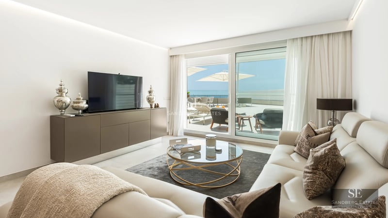 Spacious living room with panoramic sea views, light wood floors, and modern design. Abundant natural lighting.