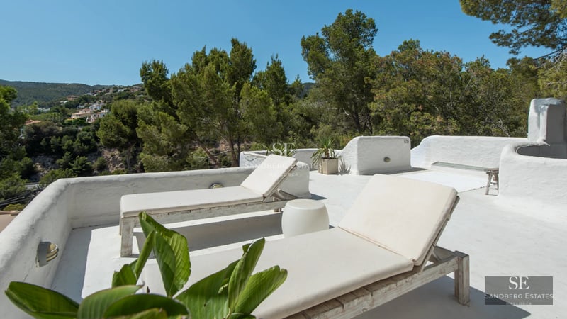 Exterior of a modern house featuring a reflective pool, large windows, and a lush garden. Minimalist and elegant architecture.