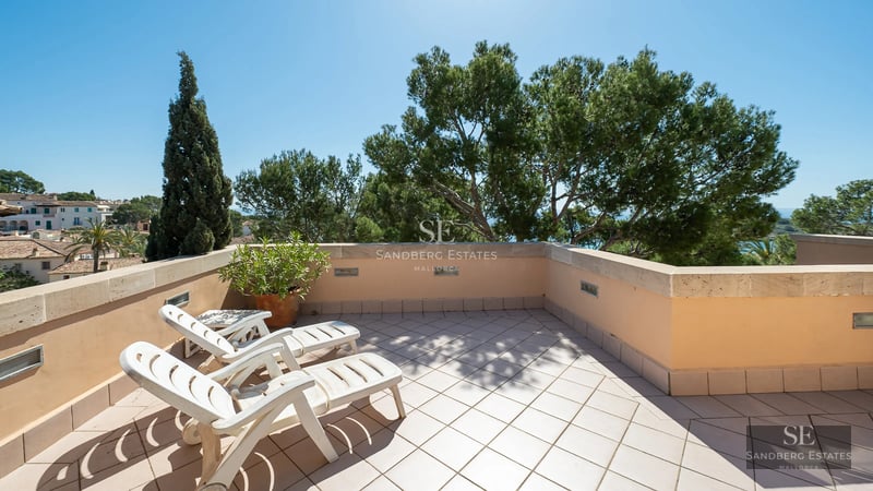 Bright living room with floor-to-ceiling windows overlooking the pool. Modern design, light floors, minimalist furniture, and unobstructed views.