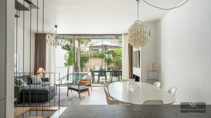 Bright open-plan living and dining room with floor-to-ceiling glass doors opening to a private pool and terrace.