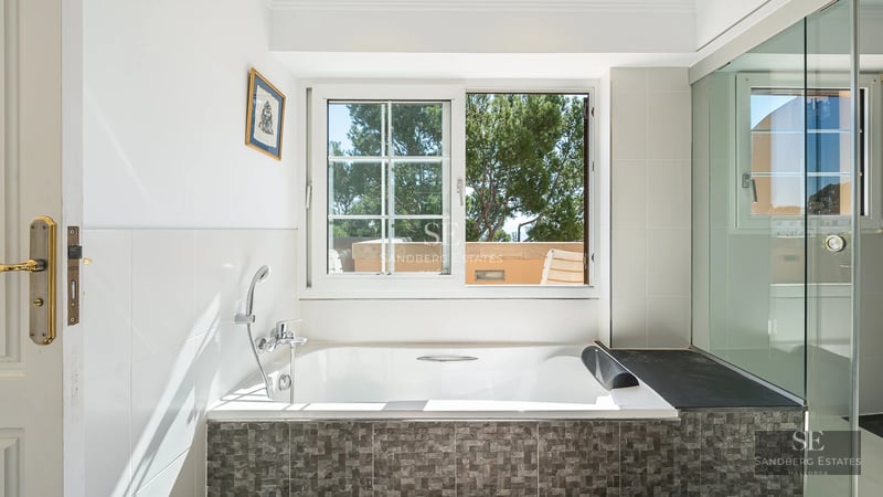 Exterior view of a modern villa featuring an infinity pool, large windows, and lush landscaping. Minimalist and elegant design.