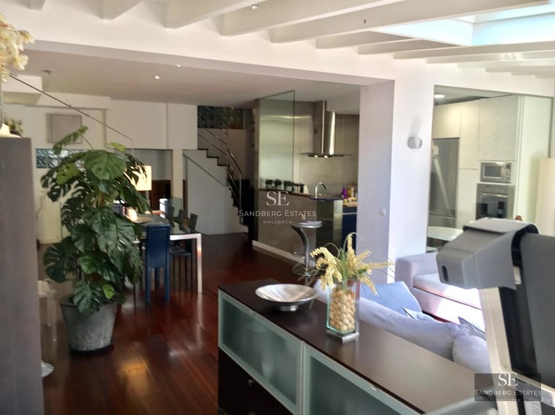 View of a modern villa with an infinity pool, sun loungers and lush vegetation. Clean and elegant architectural design.