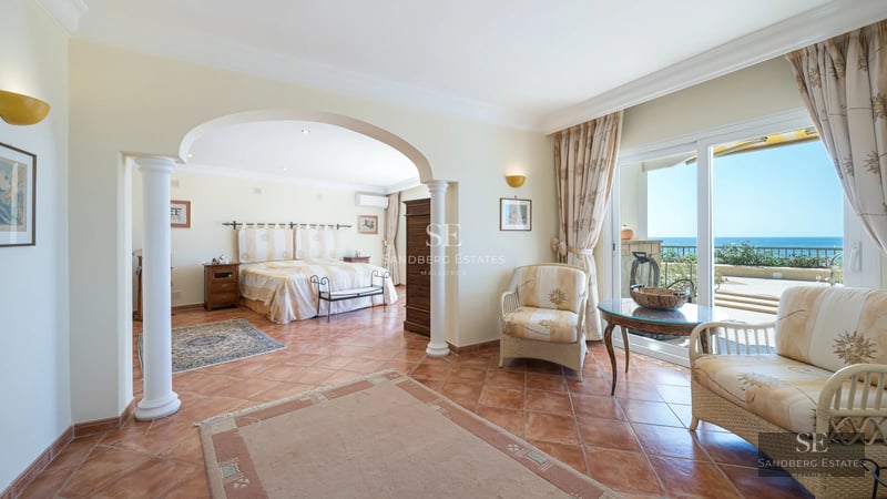 Spacious living room with floor-to-ceiling windows, modern fireplace and access to pool terrace. Elegant design and panoramic views.