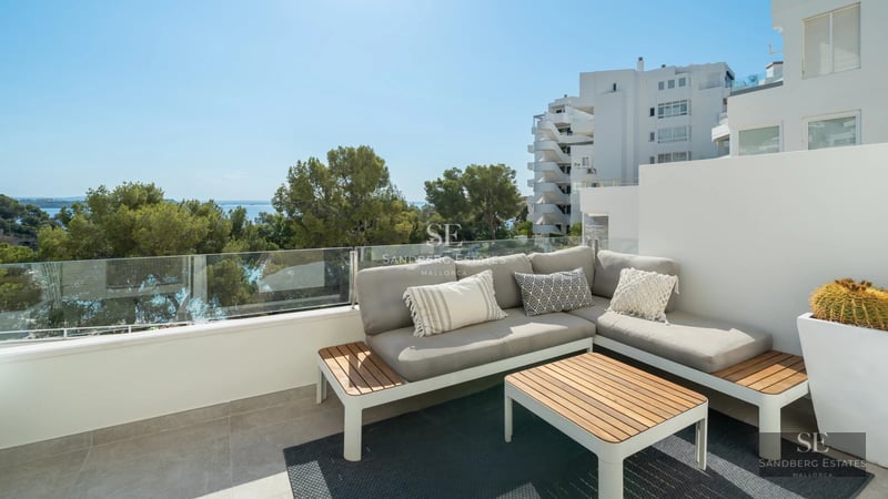 View of a luxurious villa with infinity pool, surrounded by greenery and spacious terraces. Modern and bright architecture.