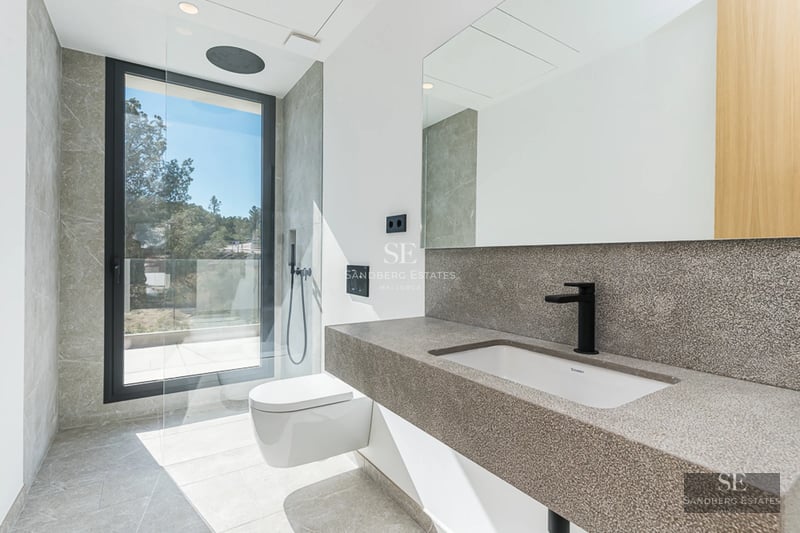 Vue d'une villa de luxe avec piscine, entourée de verdure. Architecture moderne avec de grandes baies vitrées et des finitions haut de gamme.