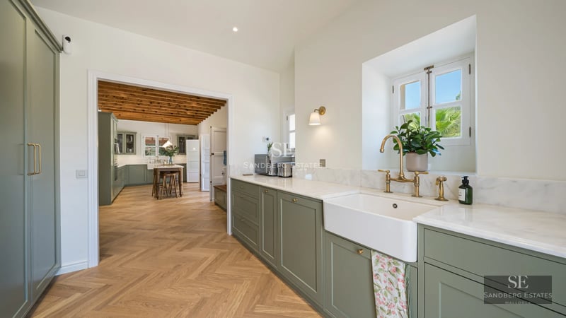 Spacious living room with floor-to-ceiling windows, designer sofas, modern rug, and fireplace. Natural light and panoramic views.