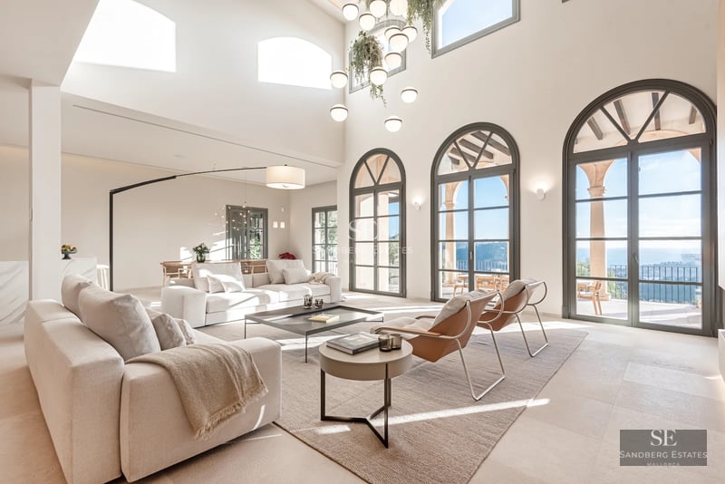 Spacious balcony with sea view. Glass railing, wooden floor, and modern outdoor furniture. Minimalist design with natural light.