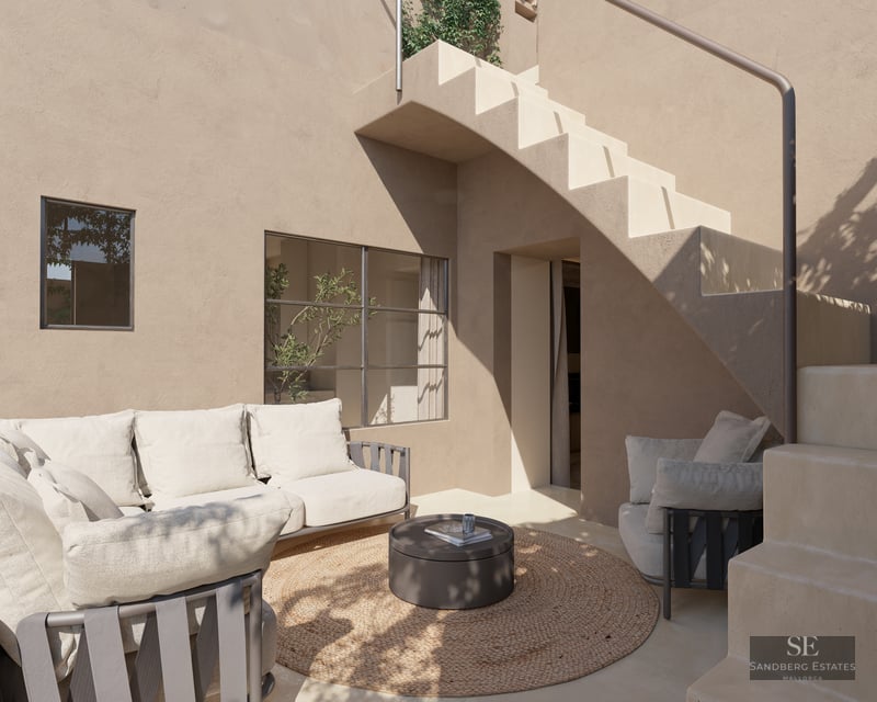 Sofa and armchair on a beige stucco terrace next to an exterior staircase and a round rug.