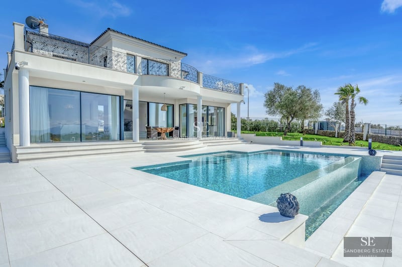 Spacious living room with pool view. Modern design, natural light, neutral colors. Light wood floors and elegant furniture.