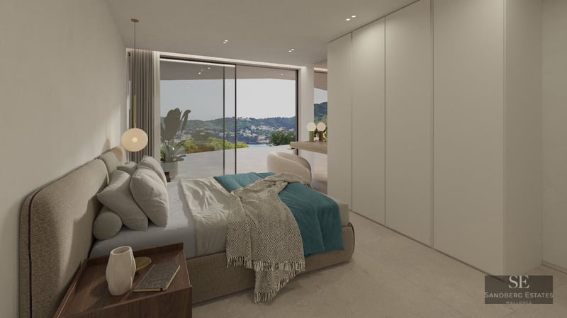 Minimalist bedroom with upholstered bed, built-in wardrobes, and glass doors opening to a scenic mountain and sea view.