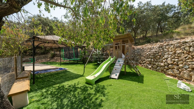 Aerial view of a modern villa featuring an infinity pool, lush garden, and minimalist design. Warm lighting and luxury finishes.