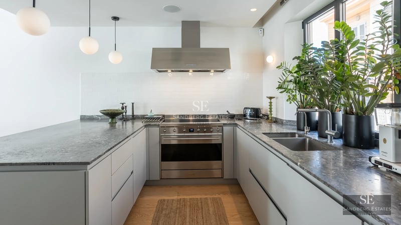 View of a luxurious villa with infinity pool, surrounded by greenery. Modern design with large windows and terrace.