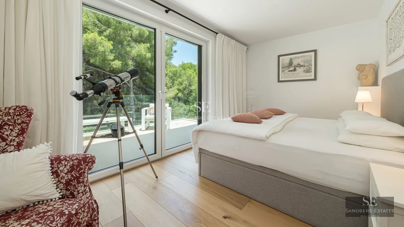 Spacious living room with ocean view windows. Modern design, leather sofas, light carpet. Abundant natural light. Open and elegant space.