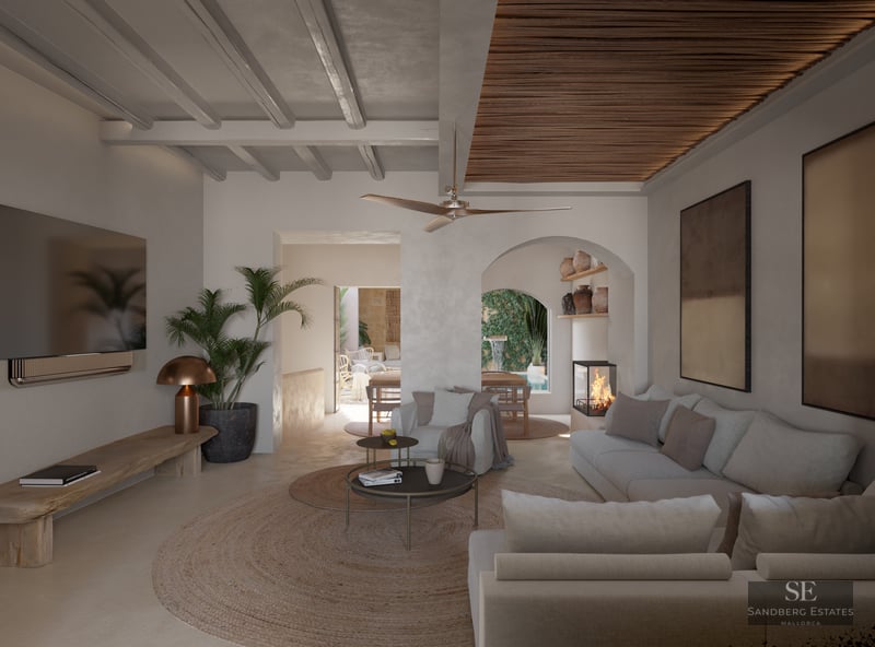 Luxurious living room featuring beige sofas, beamed ceilings, a modern fireplace, and views to a courtyard pool through an arch.