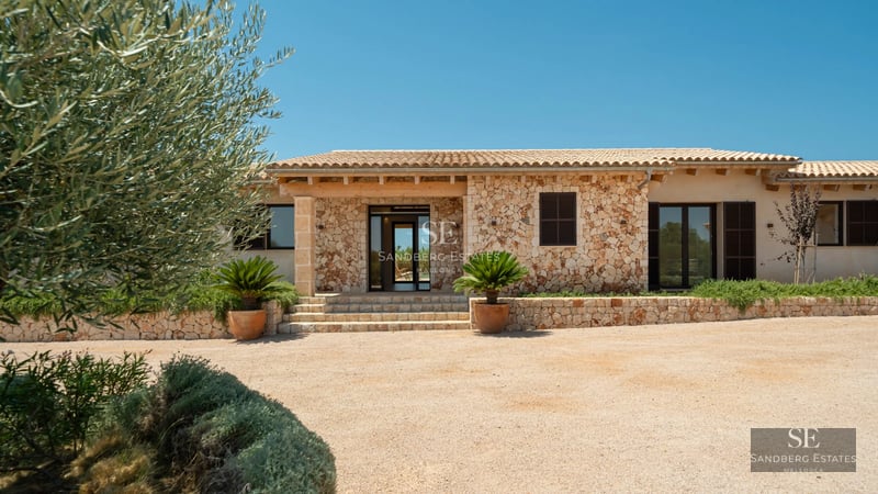 Large pool surrounded by lush greenery, with modern villa in the background. Minimalist architectural design and luxurious finishes.