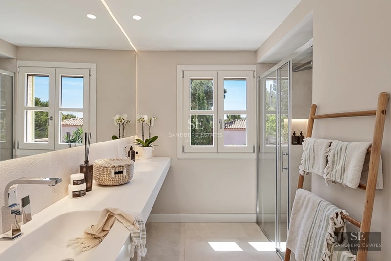 Spacious balcony with sea view, modern furniture and wooden flooring. Glass railing maximizes panoramic views.