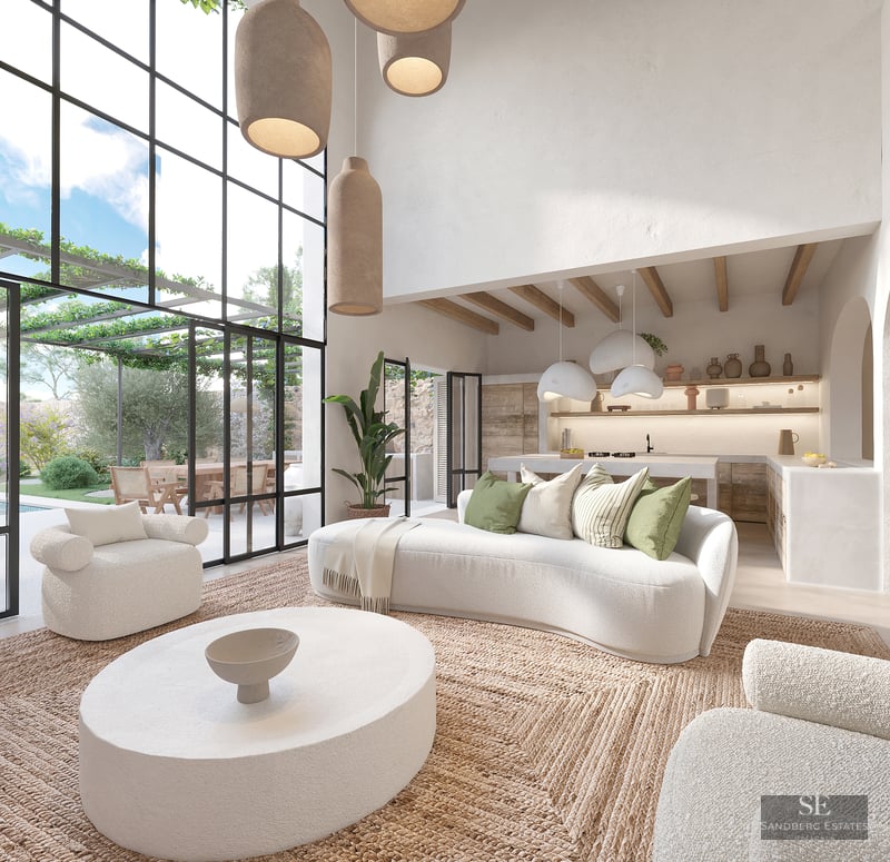 Spacious white living room with curved sofas, jute rug, and floor-to-ceiling windows overlooking a lush terrace.