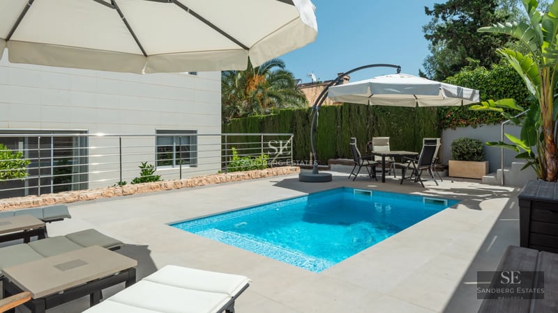 Exterior view of modern villa with infinity pool and outdoor living area. Minimalist design and panoramic views.