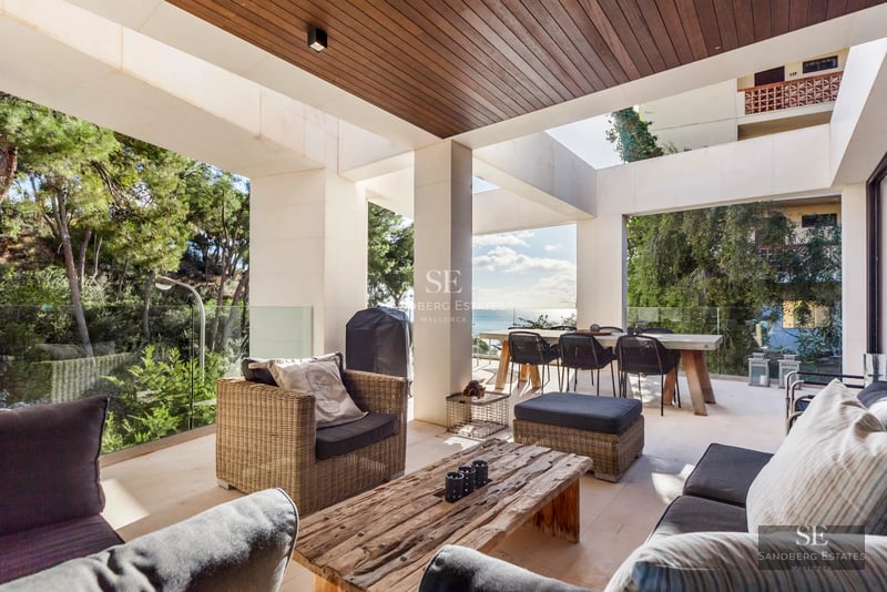 View of infinity pool, spacious terrace with sun loungers, modern architecture, lush landscaping and panoramic views.